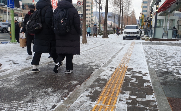 시각장애인들의 눈인 도로 위 점자블록이 눈이 내린 후 꽁꽁 얼어붙어 있다. 오가는 행인들이 미끄러운 점자블록을 피해 걷고 있다. 김지현 기자