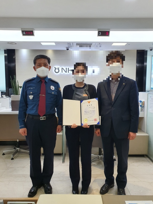 대전유성경찰서 송인성 서장이 18일 NH농협은행 대덕테크노금융센터점을 방문해 전화금융사기 피해를 예방한 은행원에게 감사장을 수여하고 있다. 이들은 지난 12일 자신을 화장품원료제조업자라고 소개하며 중고기계 구매 대금으로 현금 1400만 원을 인출 하려는 고객 보고 보이스피싱을 직감하며 112신고를 해 피해를 방지했다. 유성서 제공