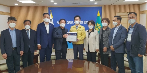 더불어민주당 박영순 의원(왼쪽에서 세 번째)과 신탄진역활성화대책위원회가 지난 7일 대전시청을 방문, 허태정 시장(가운데)에게 신탄진역 활성화 방안 마련을 촉구하는 2만 4000여 명의 서명부를 전달하고 있다. 박영순 의원실 제공