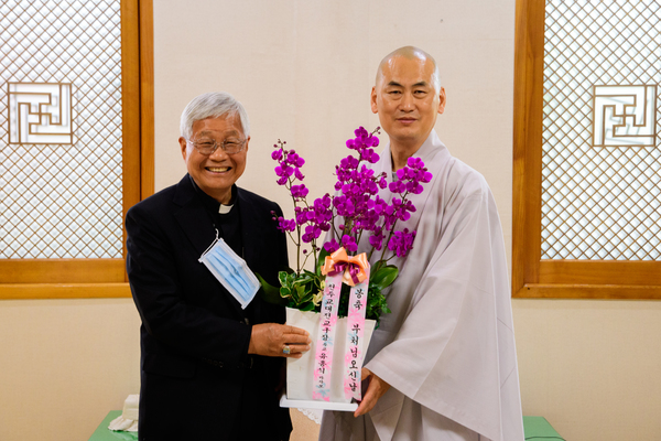 ‘부처님 오신 날’을 맞아 17일 대한불교천태종 광수사(대전 유성구 계산동)를 방문한 유흥식 천주교 대전교구장(라자로 주교, 왼쪽)이 장호 주지 스님에게 축하난을 전달하며 기념촬영을 하고 있다. 천주교 대전교구 제공