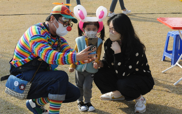 2021 아이사랑 가족사랑 축제가 지난 20일 대전 중구 서대전공원에서 열린 가운데 부모와 아이가 피에로 아저씨와 사진을 찍고 있다.  함형서 기자 foodwork23@ggilbo.com
