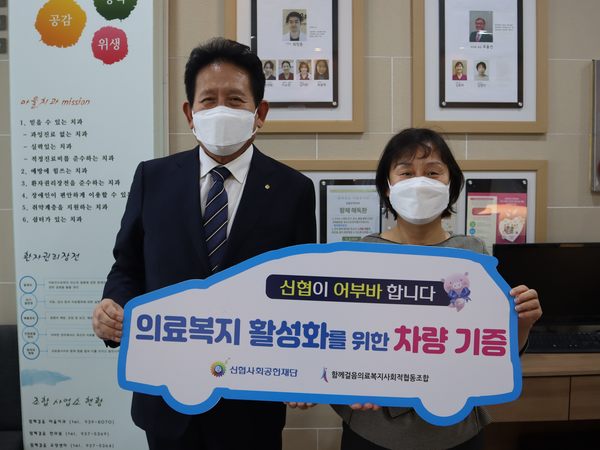 김기성 신협서울지역협의회장(왼쪽)이 12일 남영희 함께걸음의료복지사회적협동조합 이사장에게 의료복지 활성화를 위한 차량을 전달한 후 기념촬영을 하고 있다. 신협중앙회 제공