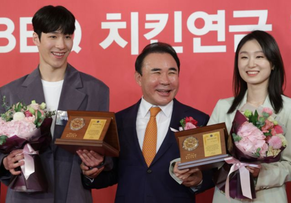 황대헌과 최민정이 21일 제너시스 BBQ 치킨연금 행복전달식에서 윤홍근 회장(가운데)으로부터 '치킨연금'을 받은 뒤 기념촬영을 하는 모습 / 연합뉴스