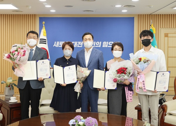 이택구 대전시장 권한대행(가운데)이 최근 시청에서 코로나19 대응 통합자원봉사지원단 유공자에게 정부 표창을 전수하고 있다. 유공자들은 면마스크 제작 및 예방접종센터 활동 등을 통해 코로나19 예방접종센터 운영 과정에서 현장 행정인력 부족의 어려움 해소에 적극 동참했다. 대전시 제공