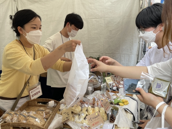 에코브레드하우스 김단아 매니저가 손님에게 빵을 전달하고 있다.