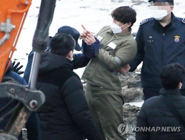 택시 기사와 동거녀를 살해한 혐의로 구속된 이기영이 6일 오후 경기도 파주 공릉천변에서 검찰 관계자들에게 시신을 매장했다고 진술한 부근을 손으로 가리키고 있다. 사진=연합뉴스