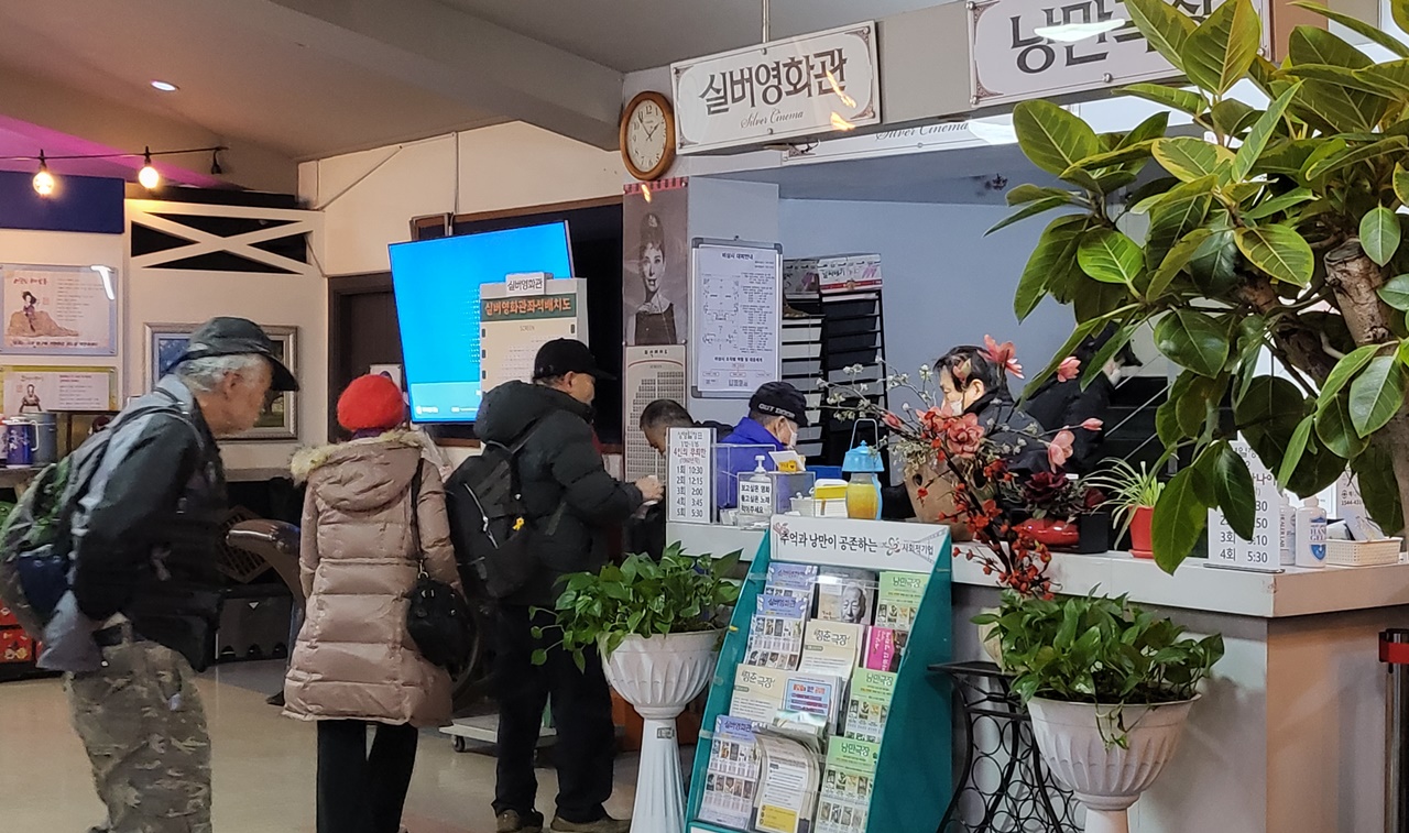 영화 상영을 앞두고 극장 내부로 들어가는 어르신들. 극장 안내를 돕는 사람도 어르신이다.