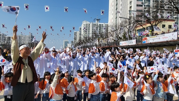 ​지난 15일 제21회 인동장터 독립만세운동 기념행사가 개최된 가운데 참석자들이 고운매합창단원의 3·1절노래에 맞춰 대한독립만세를 외치며 태극기를 높이 들고 있다. 김지현 기자