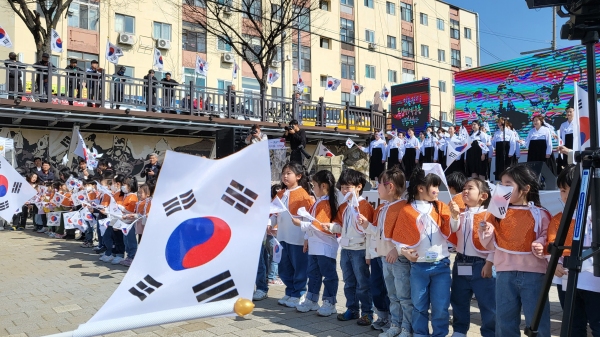 지난 15일 제21회 인동장터 독립만세운동 기념행사가 개최된 가운데 고운매합창단원의 3·1절노래에 맞춰 성남동 담쟁이어린이집 원생들이 태극기를 흔들고 있다. 김지현 기자
