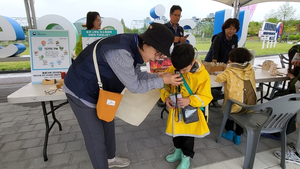 한 어린이가 나무의 나이테를 돋보기로 들여다보고 있다. 목재 100g 중 절반은 탄소로 구성돼 있어 목재 제품을 오래 사용하고 잘 보존해 탄소중립에 기여해야 한다.
