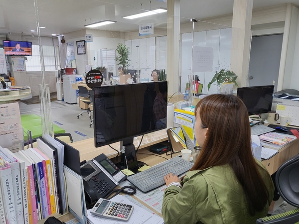 업무 처리를 하고 있는 공무원의 책상 앞 투명 아크릴 가림막에 ‘공무원의 인권을 존중합시다’라는 문구가 적힌 스티커가 붙어있다.