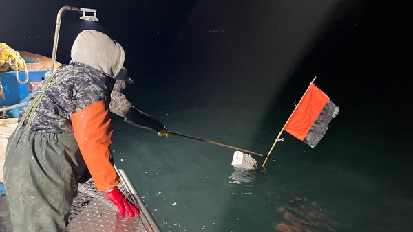 ▲ 어구명이 표시된 부표를 잡아 올리려 하고 있다.